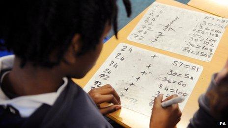 A primary school pupils works out sums in the classroom