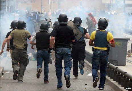 French police officers charge rioters on the tramway line in Sarcelles, a suburb north of Paris, on July 20, 2014