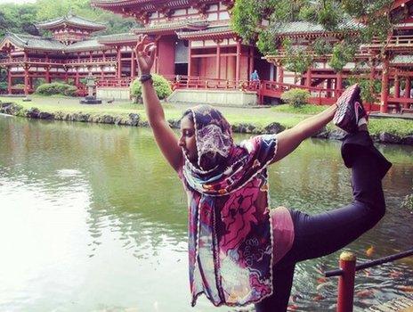 Farida Hamza doing a yoga pose near a lake