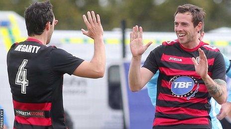 Michael Hegarty congratulates Coleraine scorer Gary Browne