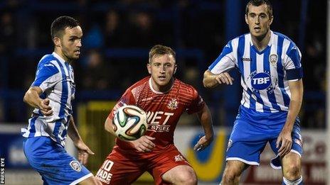 Coleraine pair Neil McCaffrey and David Ogilby battle for possession with Ports striker Mark McAllister