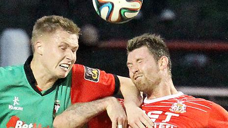 Glentoran's Calum Birney goes for a high ball with Garry Breen of Portadown