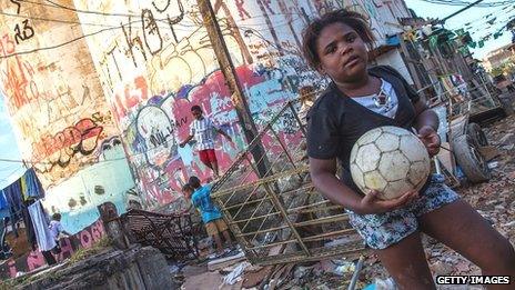 A child holds a football in a Sao Paulo favela