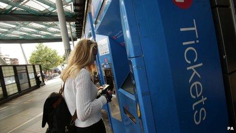 A woman using a train ticket machine