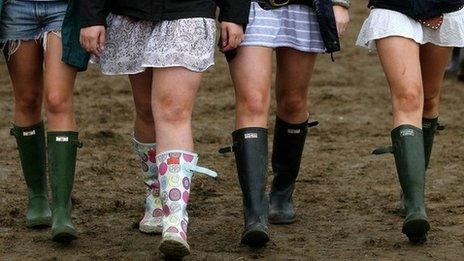 Girls walking in mud at festival