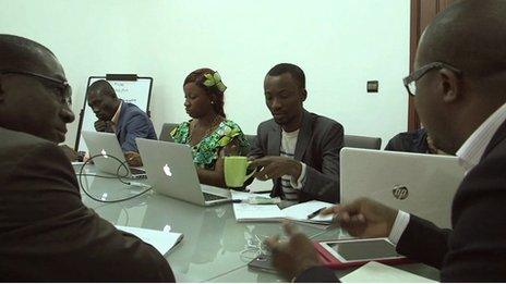 A meeting at Qelasy, people sitting in around a conference table with laptops