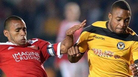 Aaron O'Connor of Newport County (right) is tackled by Swindon's Nathan Thompson