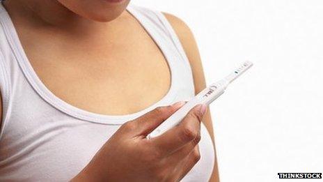 A woman checking a pregnancy test