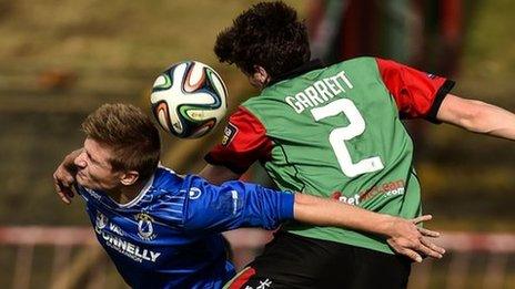 Andrew Mitchell and Willie Garrett challenge for the ball