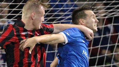 Jordan Owens of Crusaders competes against Linfield's Chris Hegarty