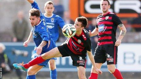 Dungannon's Josh Barton puts pressure on Coleraine's Adam Mullan