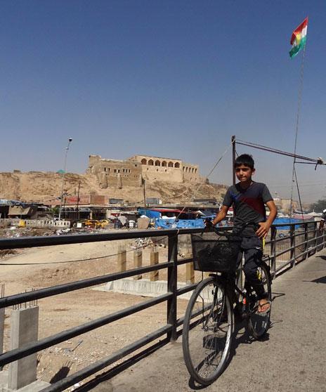 A boy cycles near the citadel in Kirkuk