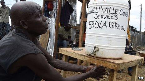 A workers washes his hands on a construction site in Monrovia on 5 October 2014