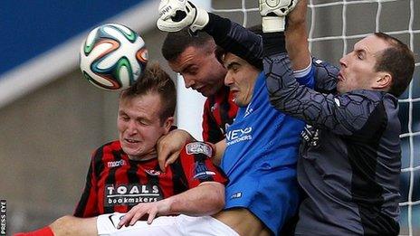 Crusaders trio Jordan Owens, Colin Coates and keeper Sean O'Neill combine to deny Linfield's Jimmy Callacher in Saturday's league game