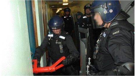 Police hitting a door with a hand-held battering ram