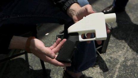 A man holds a 3D printed gun