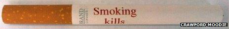 A cigarette with 'Smoking kills' written on it in red ink