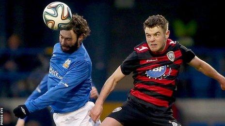 Glenavon player-manager Gary Hamilton heads while under pressure from Shane McGinty