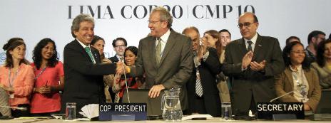 Peruvian environment minister Manuel Pulgar-Vidal shakes hands with his colleagues after sealing an agreement in Lima - 13 December 2014