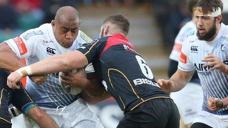 Taufa'ao Filise on the attack for Cardiff Blues is tackled by Newport Gwent Dragons' Brok Harris and James Thomas