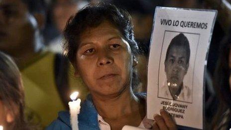 woman holds image of missing student at vigil Mexico city 31/12/14