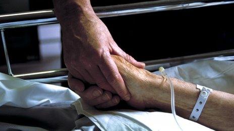 Nurse holds patient's hand