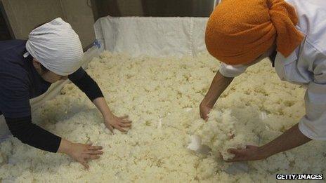 Steamed rice being spread out at a sake brewery in Japan