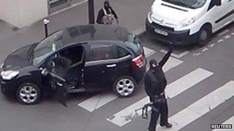 The Kouachi brothers gesture as they return to their car after the attack outside the offices of French satirical weekly newspaper Charlie Hebdo