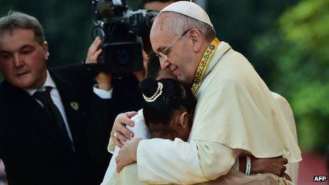 Pope Francis (R) embraces two children, including 12-year-old Glyzelle Palomar (2nd R), during his visit to the University of Santo Tomas in Manila on January 18, 2015.