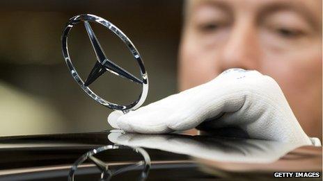 Mercedes Benz logo being polished by a worker