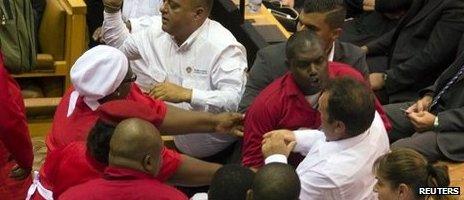 Red shirted EFF MPs brawl with white shirted security officers at South Africa's parliament