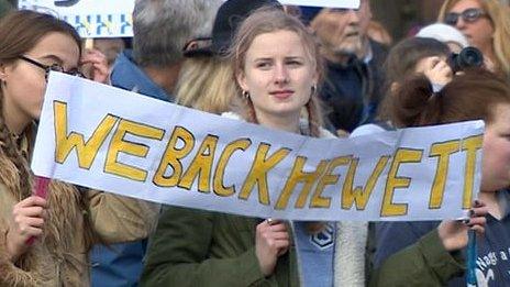 Protestors carry We Back Hewett sign