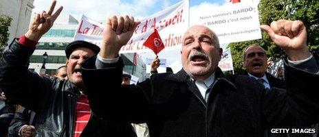 Tunisian tourist guides shout slogans as they wave banners and their national flag during a demonstration on Bourguiba Avenue in Tunis on 20 March