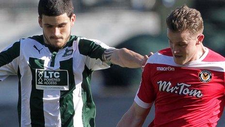 Yan Klukowski of Newport County is challenged by Anthony O'Connor of Plymouth Argyle