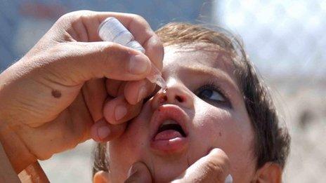 A health worker administers a polio vaccine to a child near the Afghan border in Chaman, Pakistan (22 May 2015)