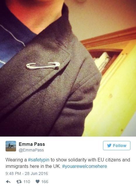 A picture of a safety pin in a woman's lapel and the words Wearing a #Safety Pin to show solidarity with EU citizens and immigrants here in the UK #You are welcome here