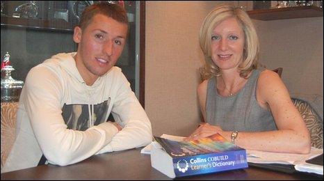 Footballer Raddy Majewski and English tutor Liz Nathan sit in the Nottingham Forest Football Club boardroom