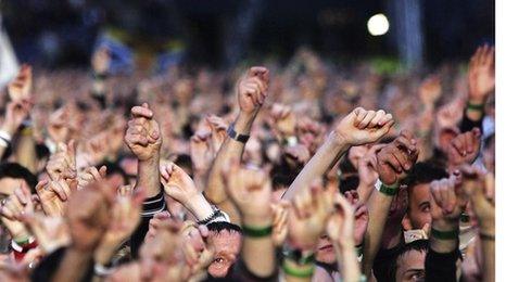 People waving their hands at a gig