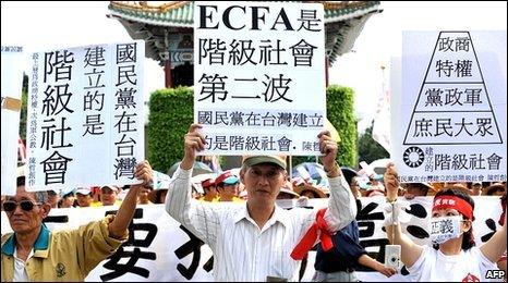 Taiwanese protesters hold up placards against trade pact