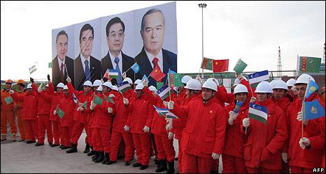 Workers hold flags at opening of gas pipeline to China in Samandepe, Turkmenistan, 14 Dec 09