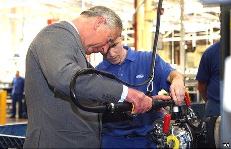 The Prince of Wales works on a turbocharger, assisted by Anthony Hookings, at the Ford engine plant near Bridgend. (Photo: David Jones/PA Wire)