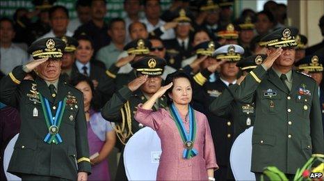 Philippine President Gloria Arroyo (C) salutes with outgoing Armed Forces chief of staff General Delfin Bangit (L) and acting chief of staff Lieutenant General Nestor Ochoa (R) during the testimonial parade for Bangit at the military headquarters in Manila on 22 June 2010.