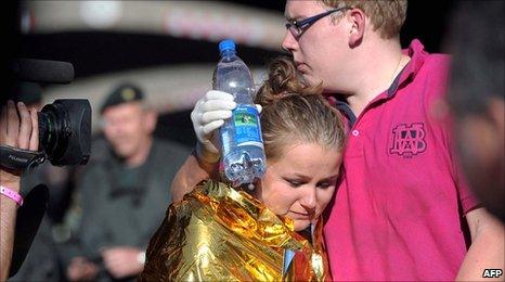 A man comforts a woman at the Duisburg music festival