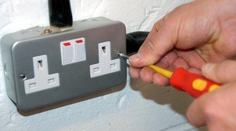 Electrician mending plug socket