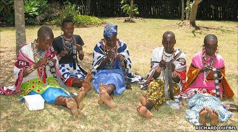 Nana Litgens (centre, in blue) and other Maasai women thread beads