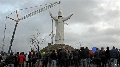 People watch as a crane lifts into place the statue's head in Swiebodzin. Photo: 6 November 2010