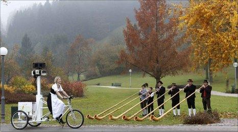 A woman on a Street View bike passes German musicians