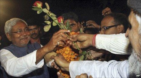 Nitish Kumar accepts flowers from supporters after his election victory in Patna, on 24 Nov 2010