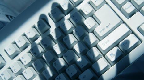 Hand in silhouette over a keyboard