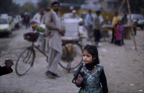 A Pakistani girl plays with a toy gun in Islamabad